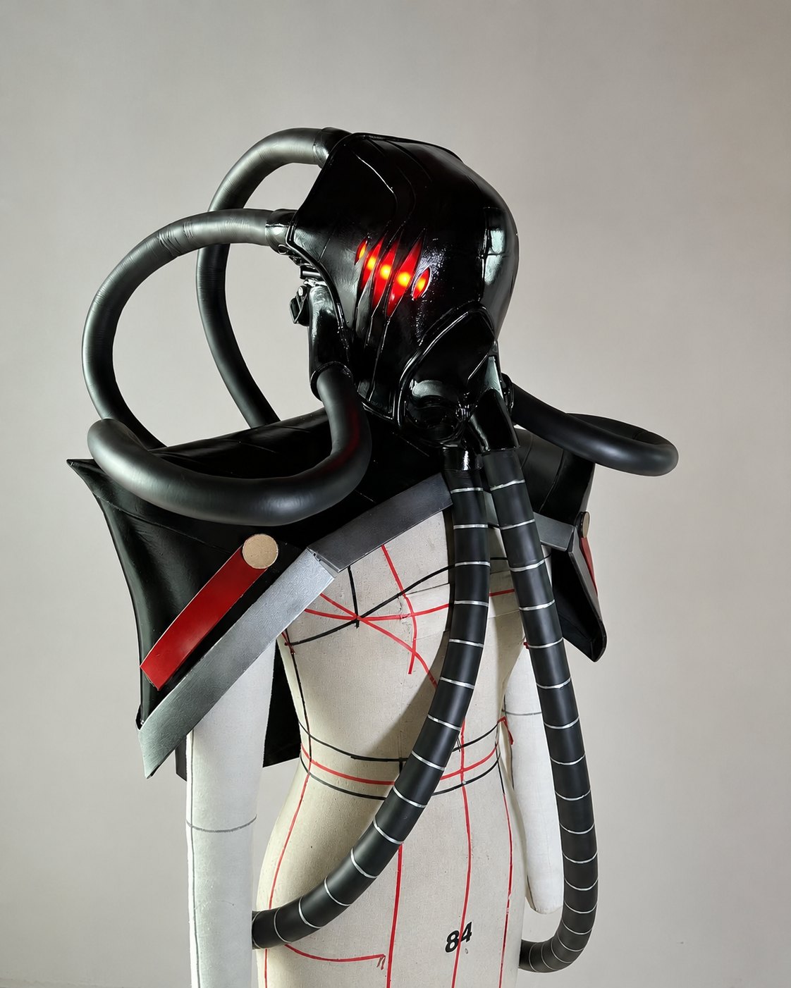 Emperor's Blade cosplay helmet armor prop set with black helmet, red light-up eye detail, shoulder armor, and backpack tube structure.