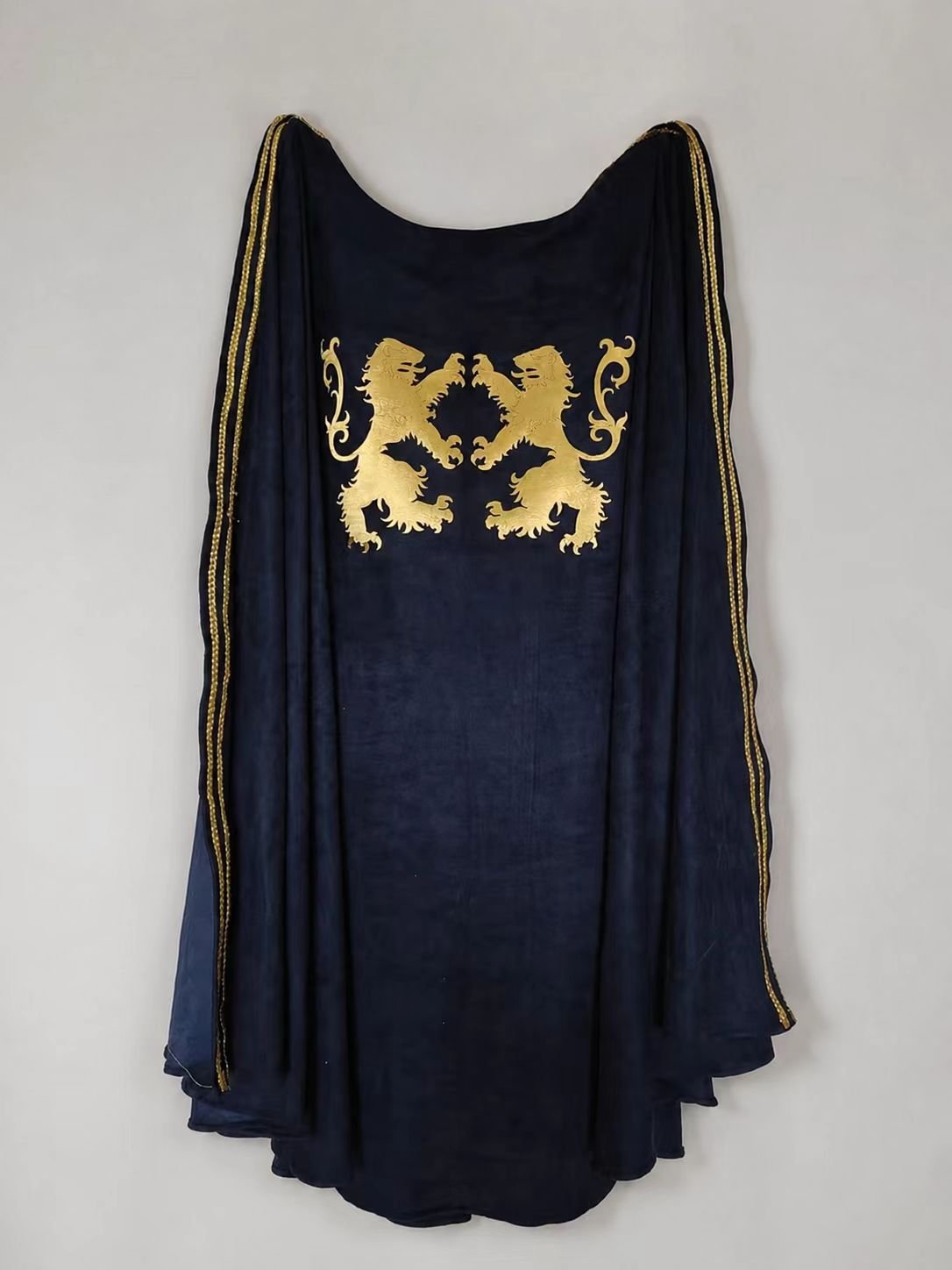 Blue medieval cosplay cloak with paired gold lions rampant laid flat.