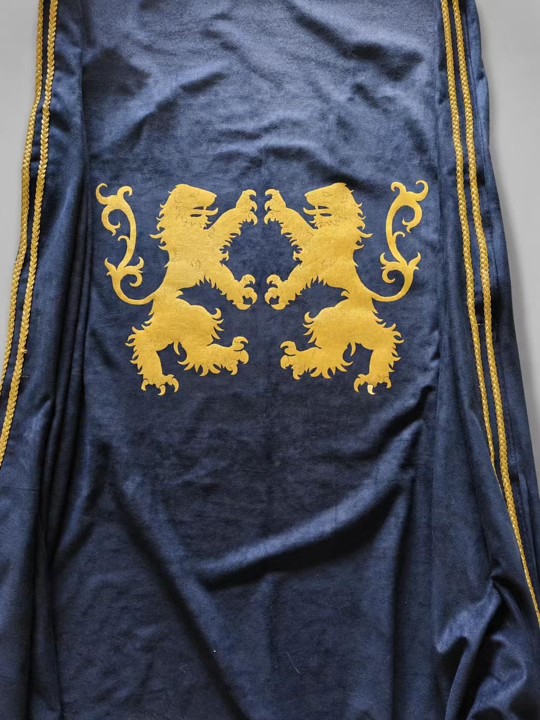 Close-up of blue medieval cosplay fabric with gold lions rampant.