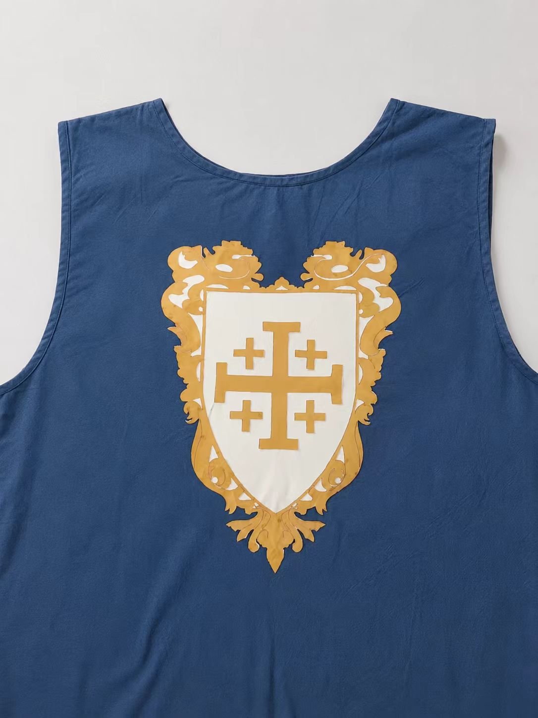 Blue medieval cosplay surcoat close-up with Jerusalem cross style crest.