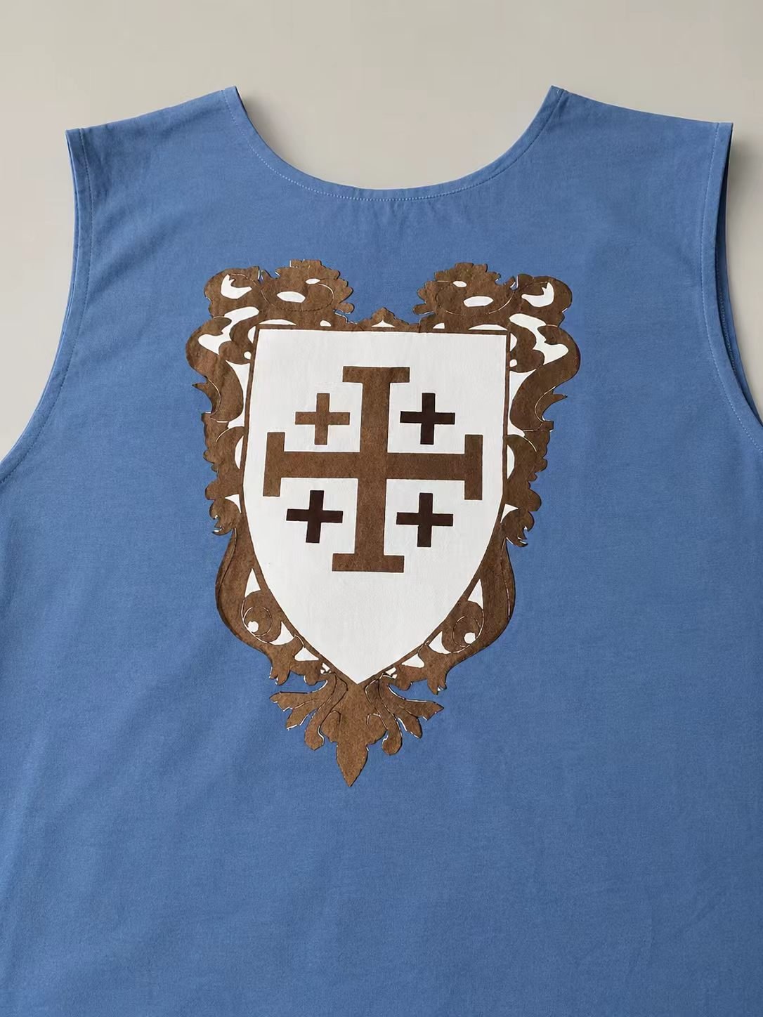Close view of blue medieval cosplay surcoat with Jerusalem cross crest.