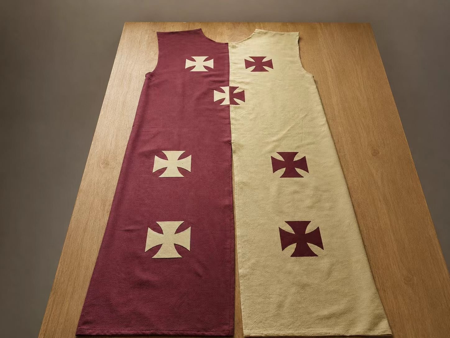 Flat burgundy and cream medieval cosplay tabard with cross motifs.