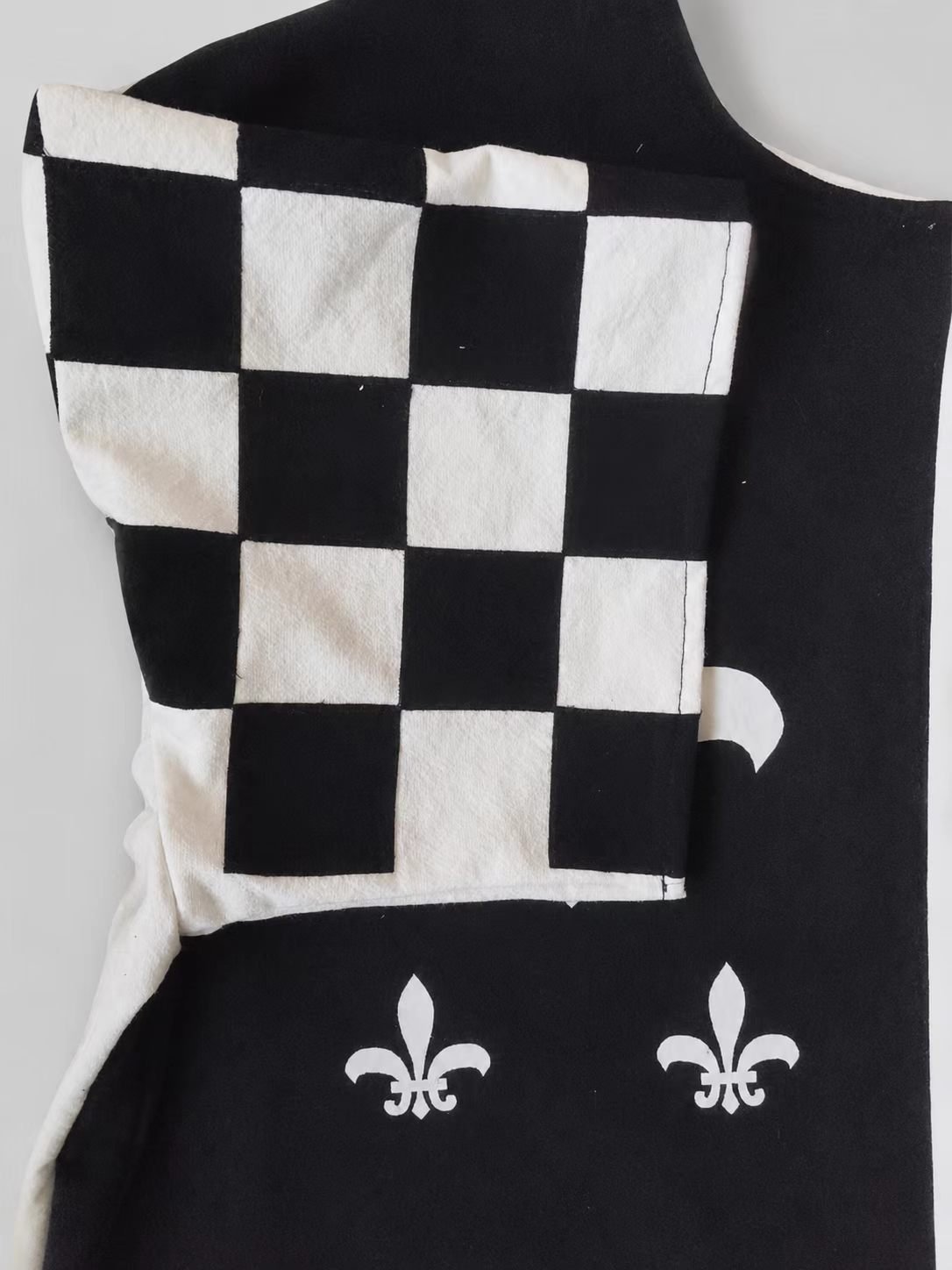Close-up of black and white checker sleeve construction on medieval cosplay tabard.