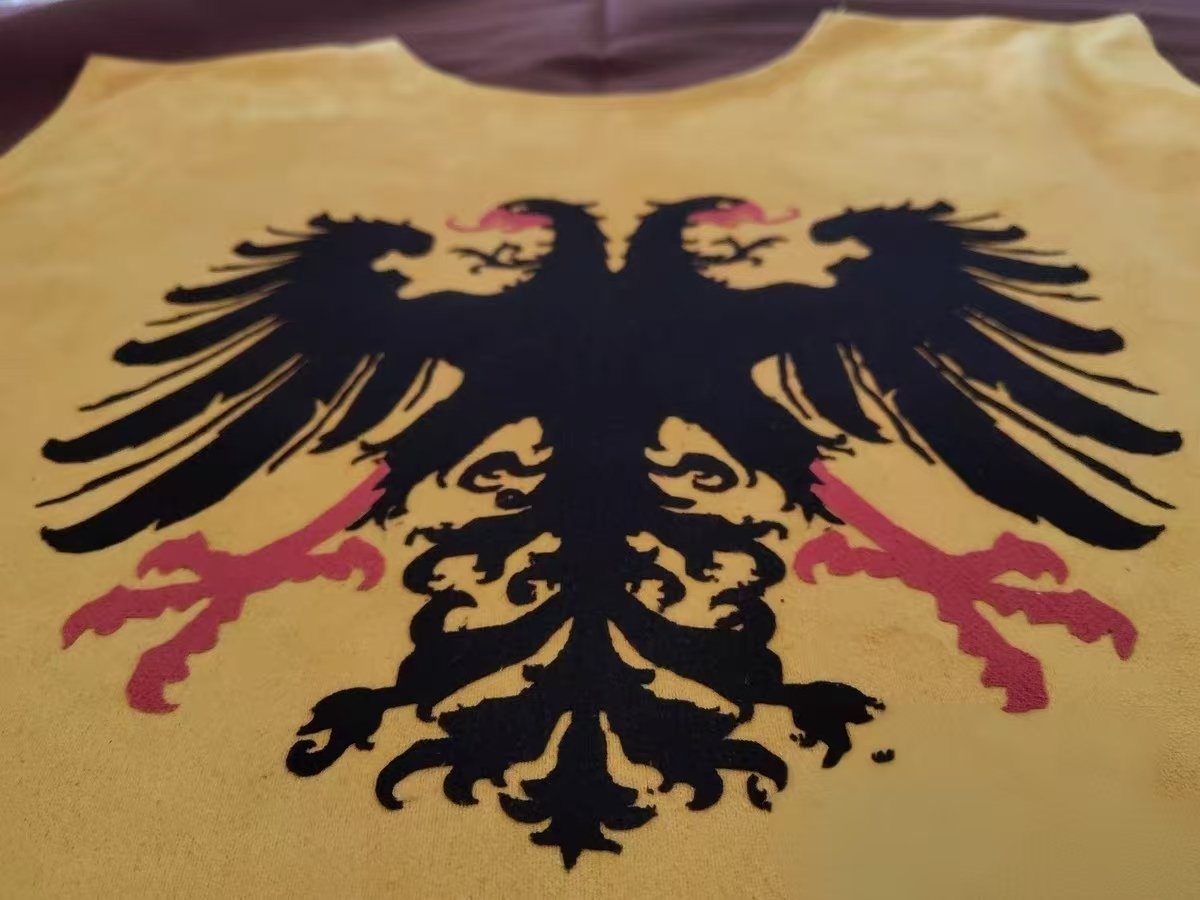 Gold double eagle applique on yellow medieval cosplay fabric.