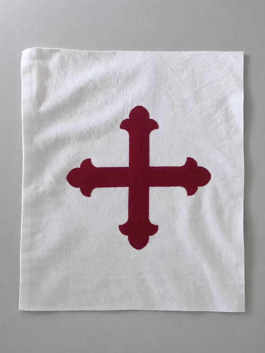 White medieval cosplay textile patch with red cross symbol.