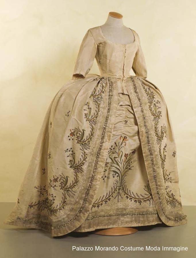 A refined dessert-inspired character cosplay with ornate textile layers and theatrical detail.