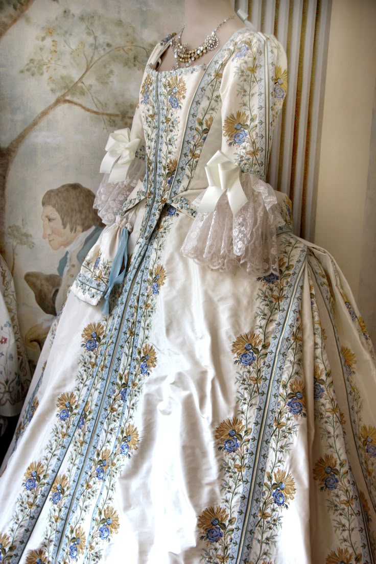 An ice-blue anime princess cosplay with lace, crown detail, and ceremonial staff prop.