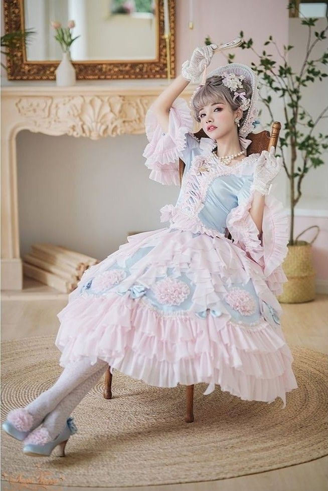 A pink rococo-inspired cosplay detail with pearl jewelry, corset structure, and fan accessory.